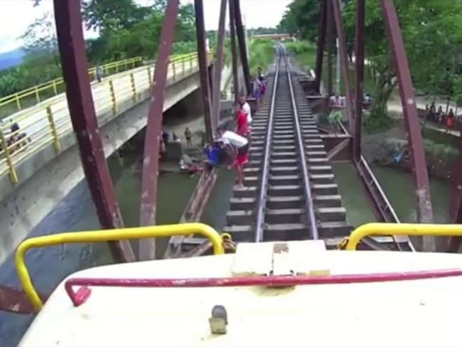 Momento en que el tren se acercaba y los jóvenes se lanzan al río. Foto: Cortesía: Fenoco