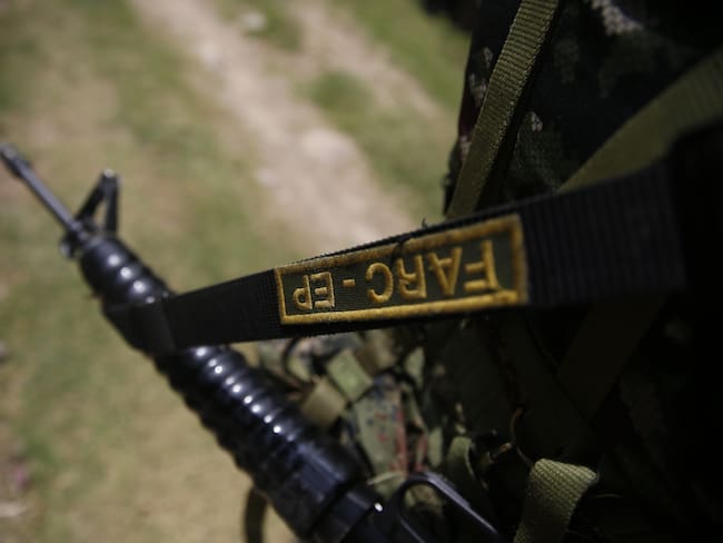 AME2623. TACUEYÓ (COLOMBIA), 26/09/2023.- Un guerrillero de las disidencias de las FARC sostiene un arma durante la liberación del soldado Juan David Estrada, hoy, en Tacueyó, zona del Cauca (Colombia).