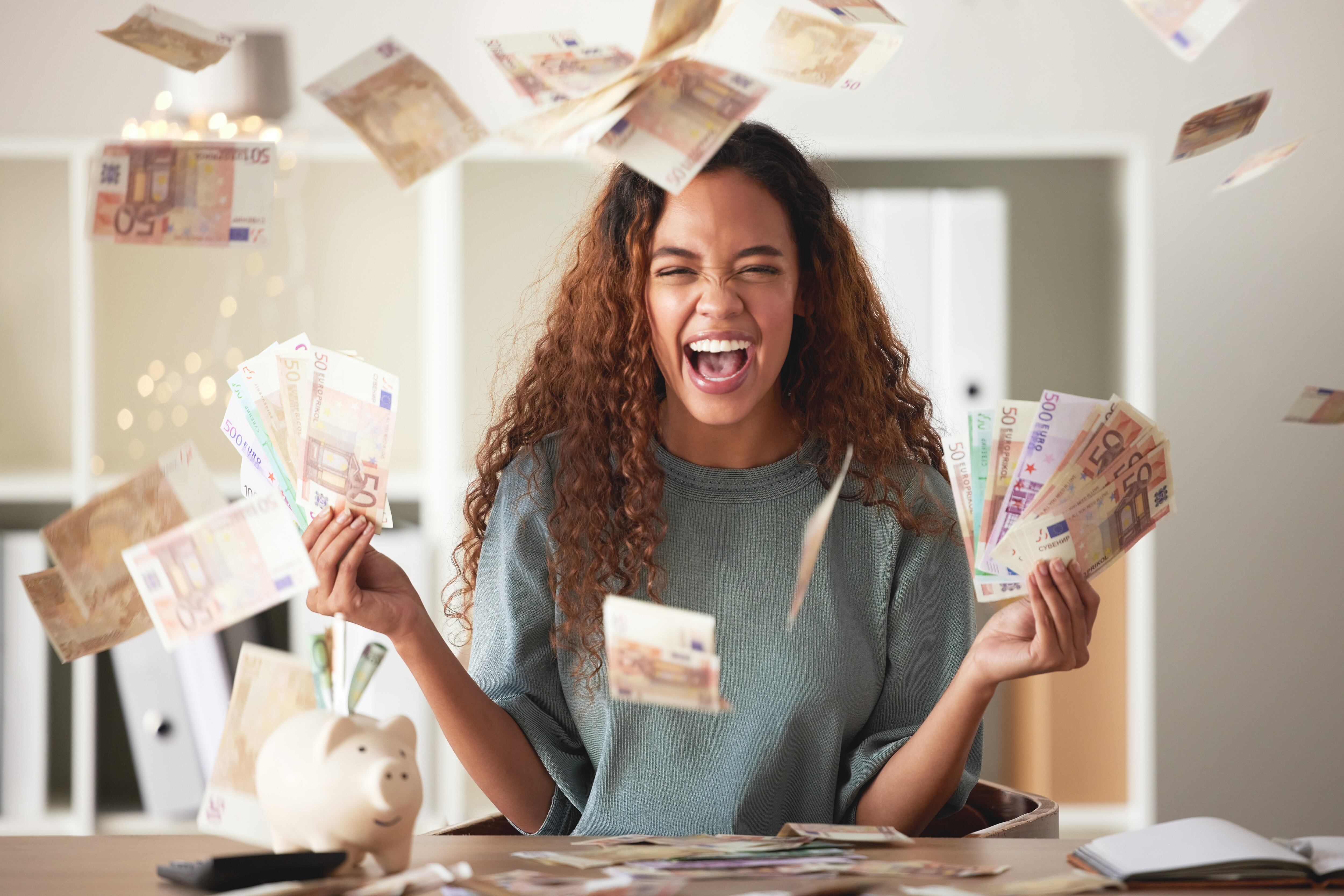 Mujer sintiéndose feliz mientras tiene una gran cantidad de dinero en sus manos / Foto: GettyImages