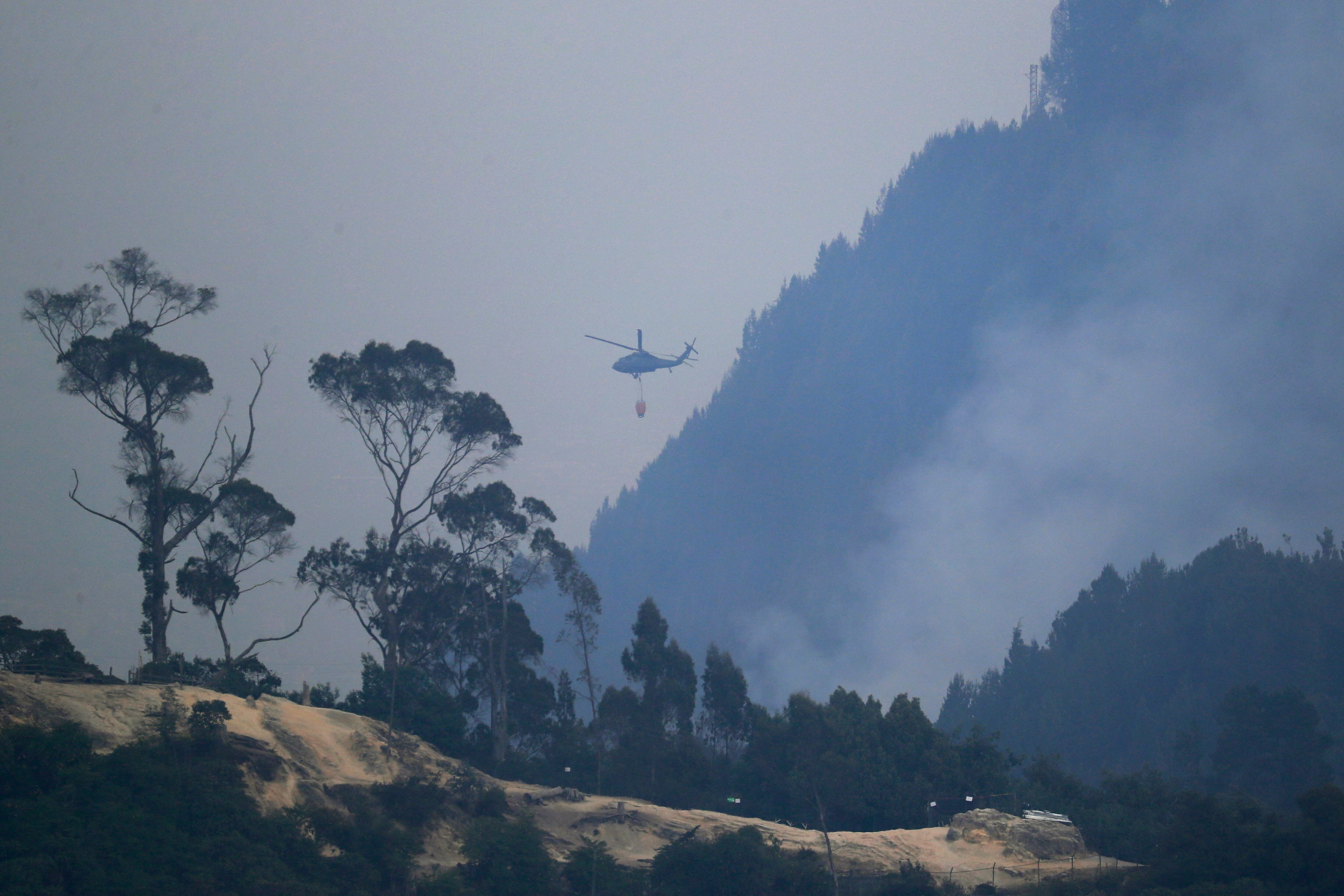 Un helicóptero combate el incendio forestal en el cerro El Cable, en Bogotá (Colombia). EFE/ Carlos Ortega