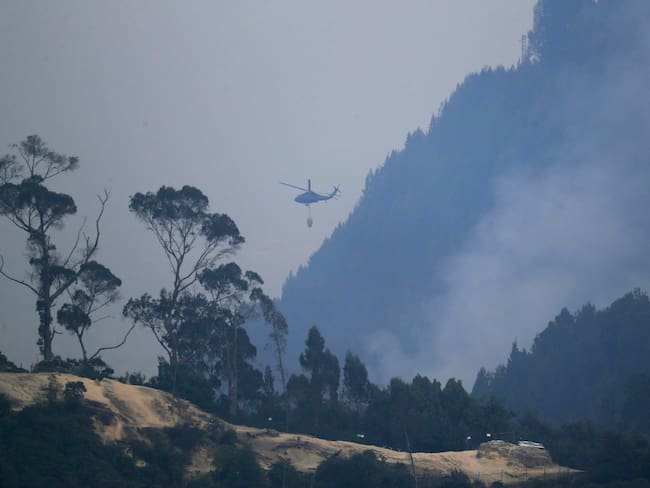 Un helicóptero combate el incendio forestal en el cerro El Cable, en Bogotá (Colombia). EFE/ Carlos Ortega