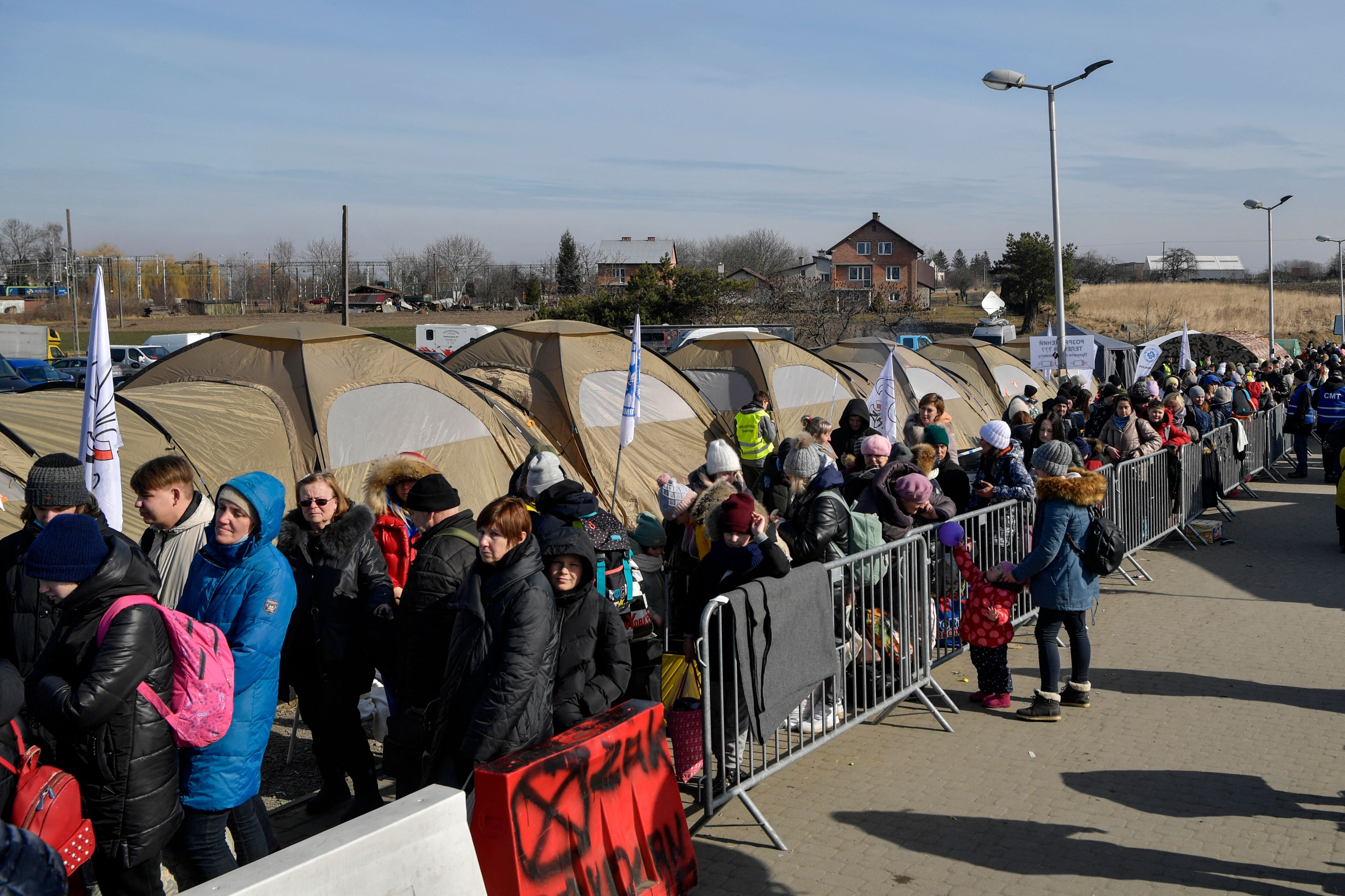 Refugees queue as they wait for further transport at the Medyka border crossing, after crossing at the Ukrainian-Polish border, southeastern Poland on March 12, 2022. - More than two and a half million people have fled the "senseless war" in Ukraine, the UN says -- more than half to Poland. (Photo by Louisa GOULIAMAKI / AFP) (Photo by LOUISA GOULIAMAKI/AFP via Getty Images)
