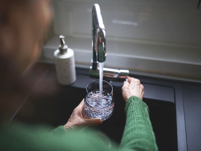 Imagen de referencia de persona cerrando una llave de agua. Foto: Getty Images