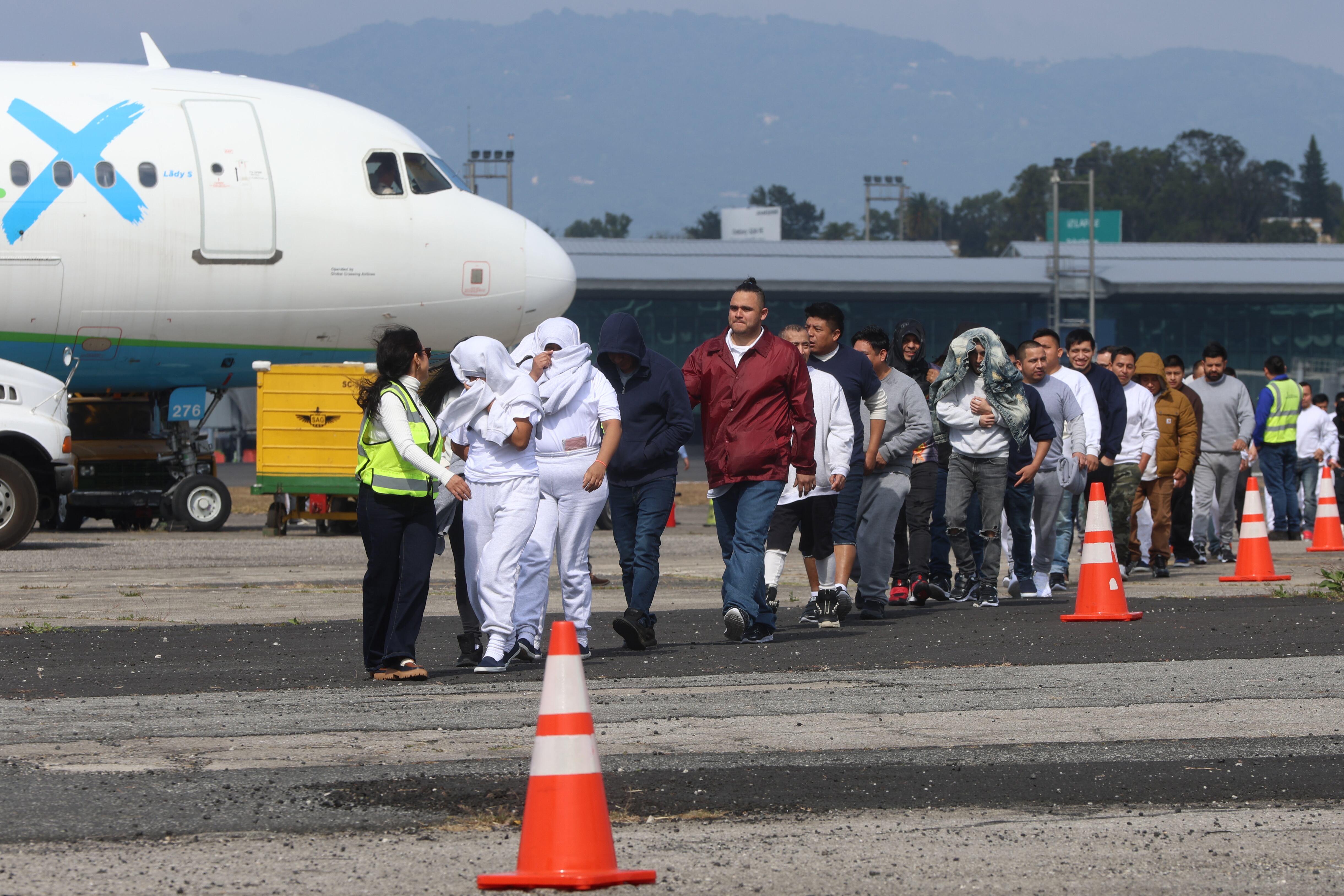 Un grupo de migrantes guatemaltecos deportados caminan por la pista de la Base Aérea de Guatemala FOTO:  EFE/ Mariano Macz