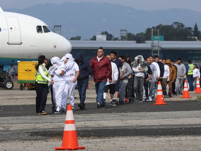 Un grupo de migrantes guatemaltecos deportados caminan por la pista de la Base Aérea de Guatemala FOTO: EFE/ Mariano Macz