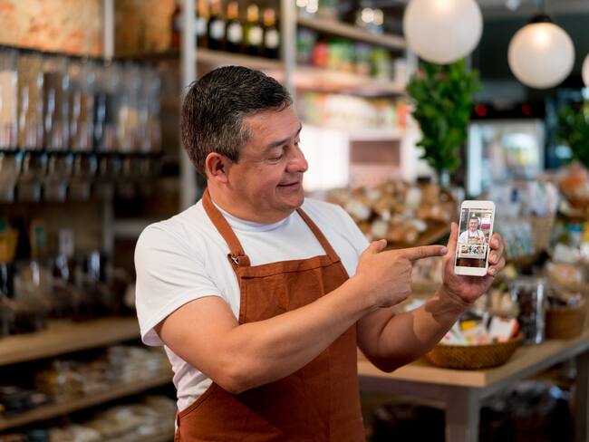 Dueño de negocio colombiano abriendo su tienda virtual de comida (Getty Images)