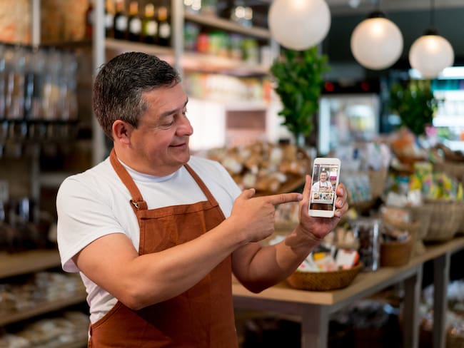 Dueño de negocio colombiano abriendo su tienda virtual de comida (Getty Images)