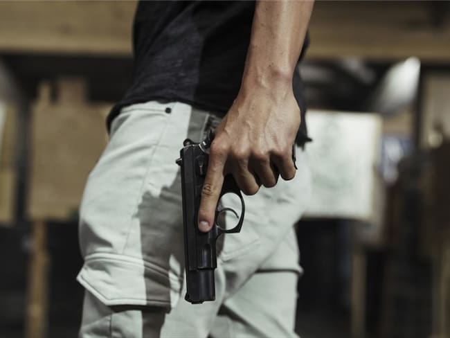 Imagen de referencia de hombre con una pistola. Foto: Getty Images / Westend61