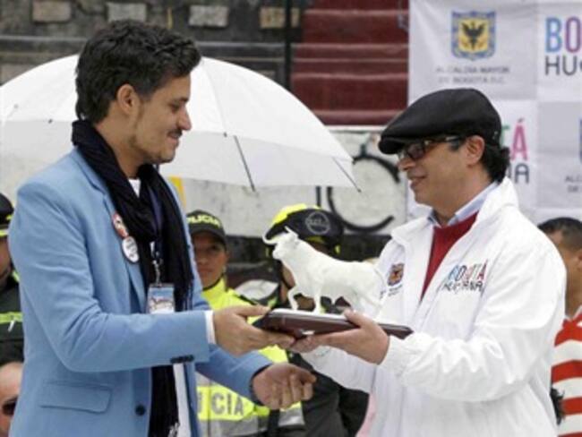 El alcalde de Bogotá, Gustavo Petro, recibe del animalista Leonardo Anselmi el 'toro blanco'.
