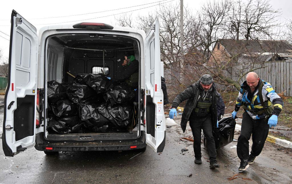 Trabajadores comunales cargan el cuerpo de un civil asesinado en la localidad de Bucha(Photo by Sergei SUPINSKY / AFP) (Photo by SERGEI SUPINSKY/AFP via Getty Images)