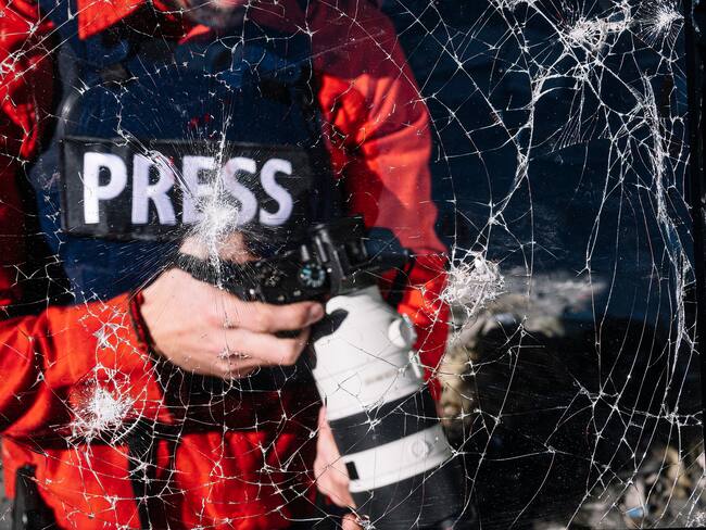 Periodista de guerra con cámara digital en zona de guerra. Foto: Getty Images/ Fotografía de stock