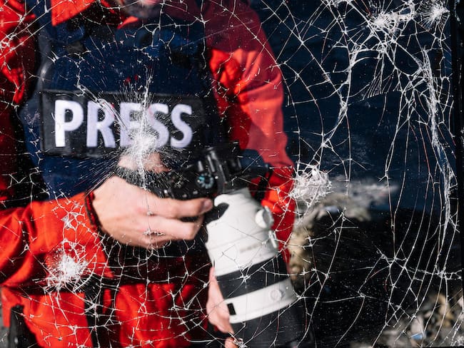 Periodista de guerra con cámara digital en zona de guerra. Foto: Getty Images/ Fotografía de stock