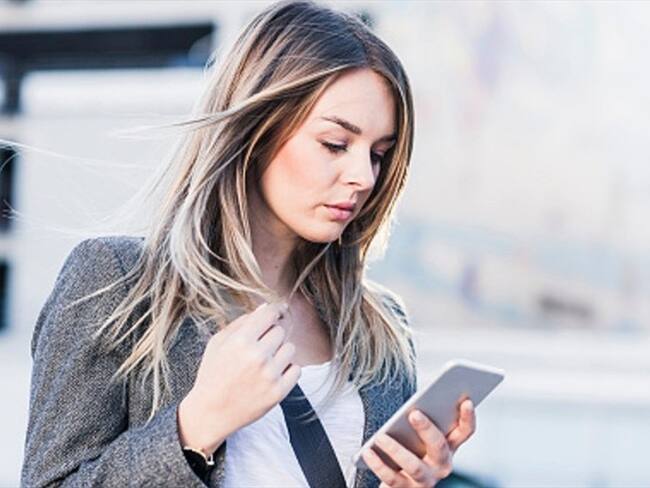 Imagen de referencia- Mujer observando su celular. Foto: Getty Images