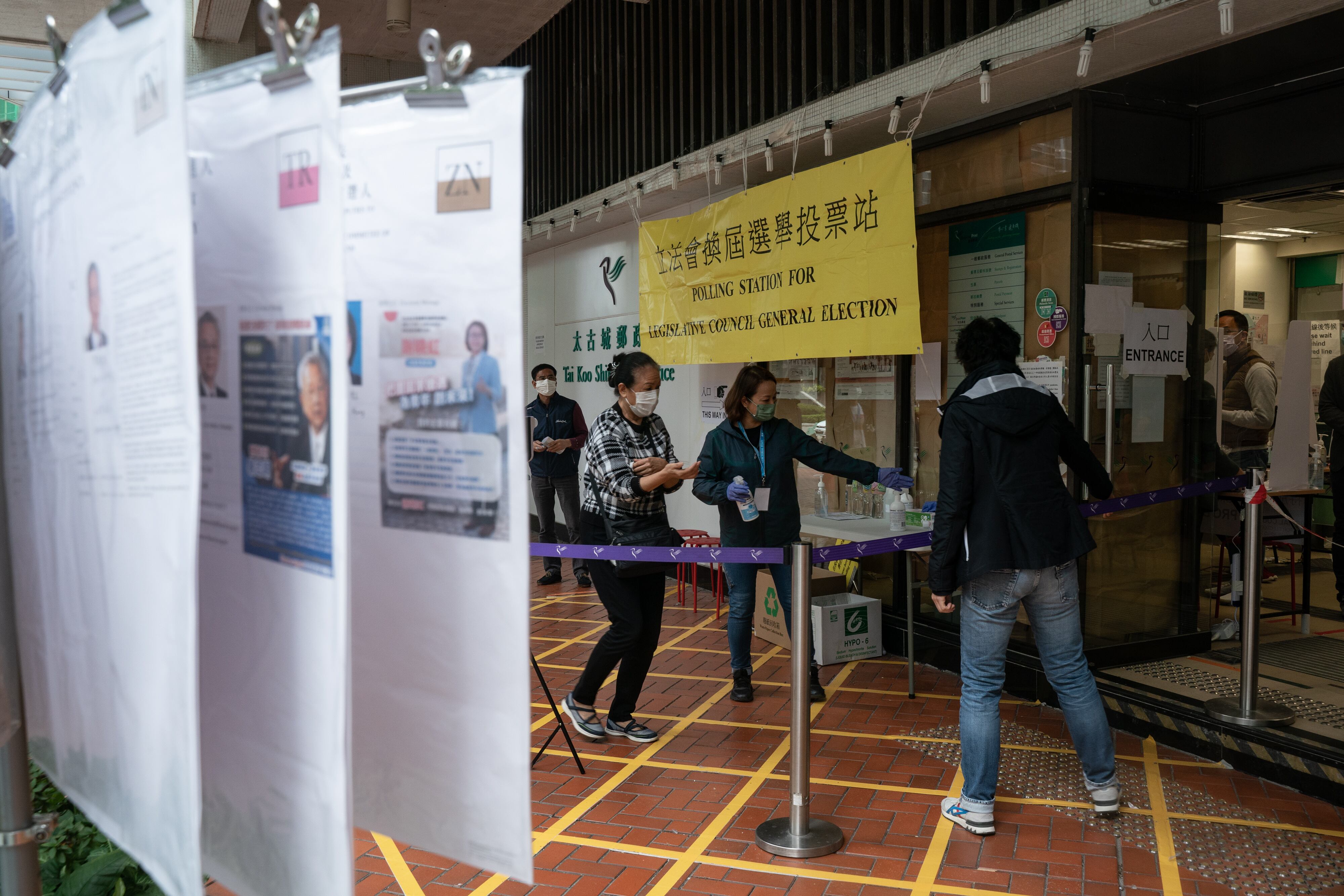 HONG KONG, CHINA - DECEMBER 19: People enter a polling station during the Legislative Council election on December 19, 2021 in Hong Kong, China. Hong Kong holds its first major election since Beijing dictated only "patriots" can govern the city, a move that wiped out the pro-democracy bloc and threatens to diminish voter turnout. (Photo by Anthony Kwan/Getty Images)