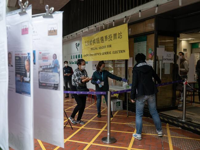 HONG KONG, CHINA - DECEMBER 19: People enter a polling station during the Legislative Council election on December 19, 2021 in Hong Kong, China. Hong Kong holds its first major election since Beijing dictated only &quot;patriots&quot; can govern the city, a move that wiped out the pro-democracy bloc and threatens to diminish voter turnout. (Photo by Anthony Kwan/Getty Images)