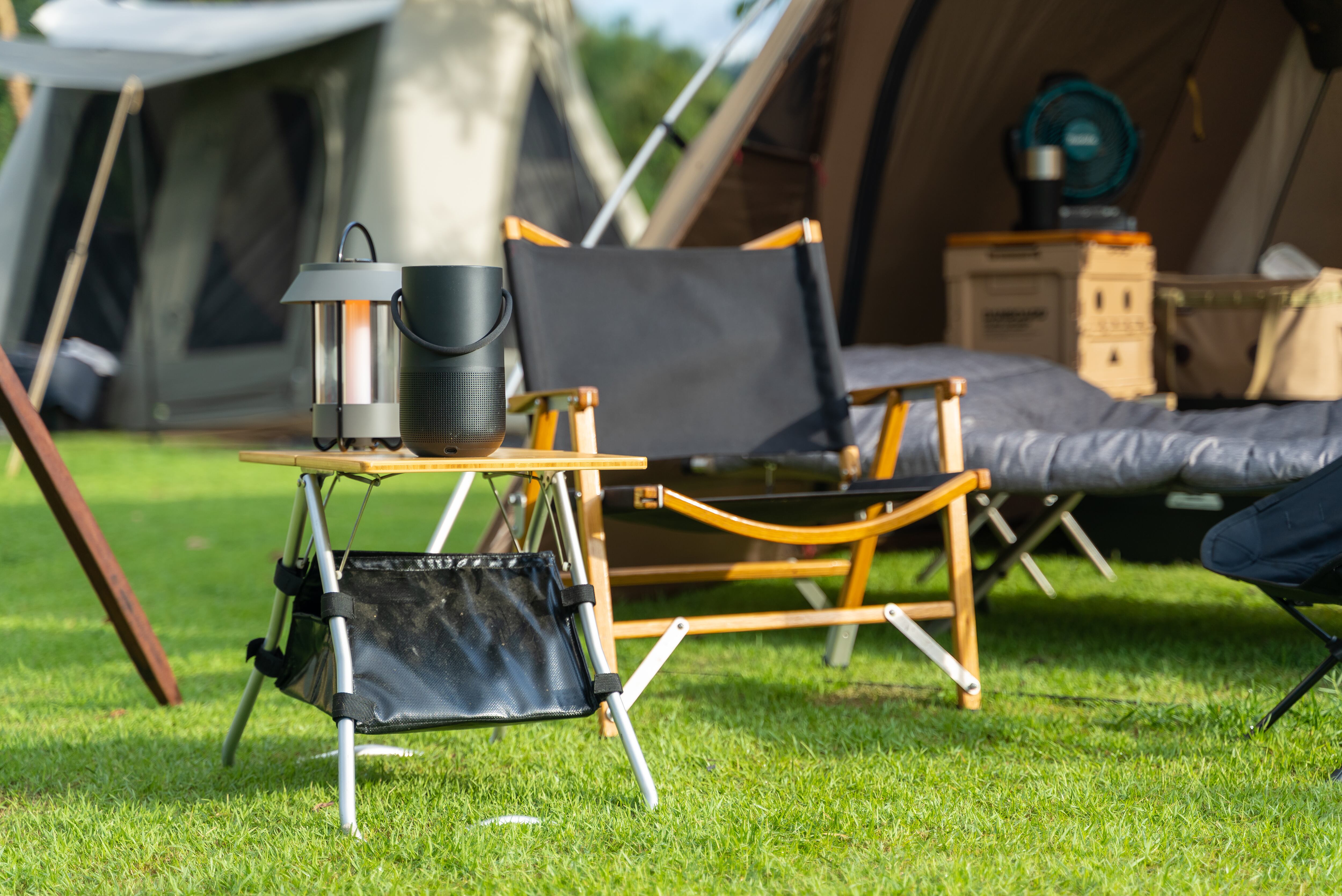 Camping folding chairs and wooden table in front the tent. Concept of camping life and weekend activity.