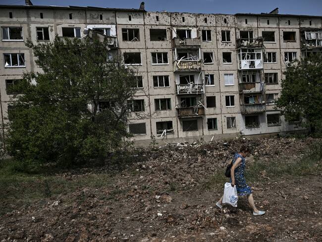 A woman walks in front of damaged apartment building after a missile strike in the city of Soledar, in the eastern Ukrainian region of Donbas on June 4, 2022. (Photo by ARIS MESSINIS / AFP) (Photo by ARIS MESSINIS/AFP via Getty Images)