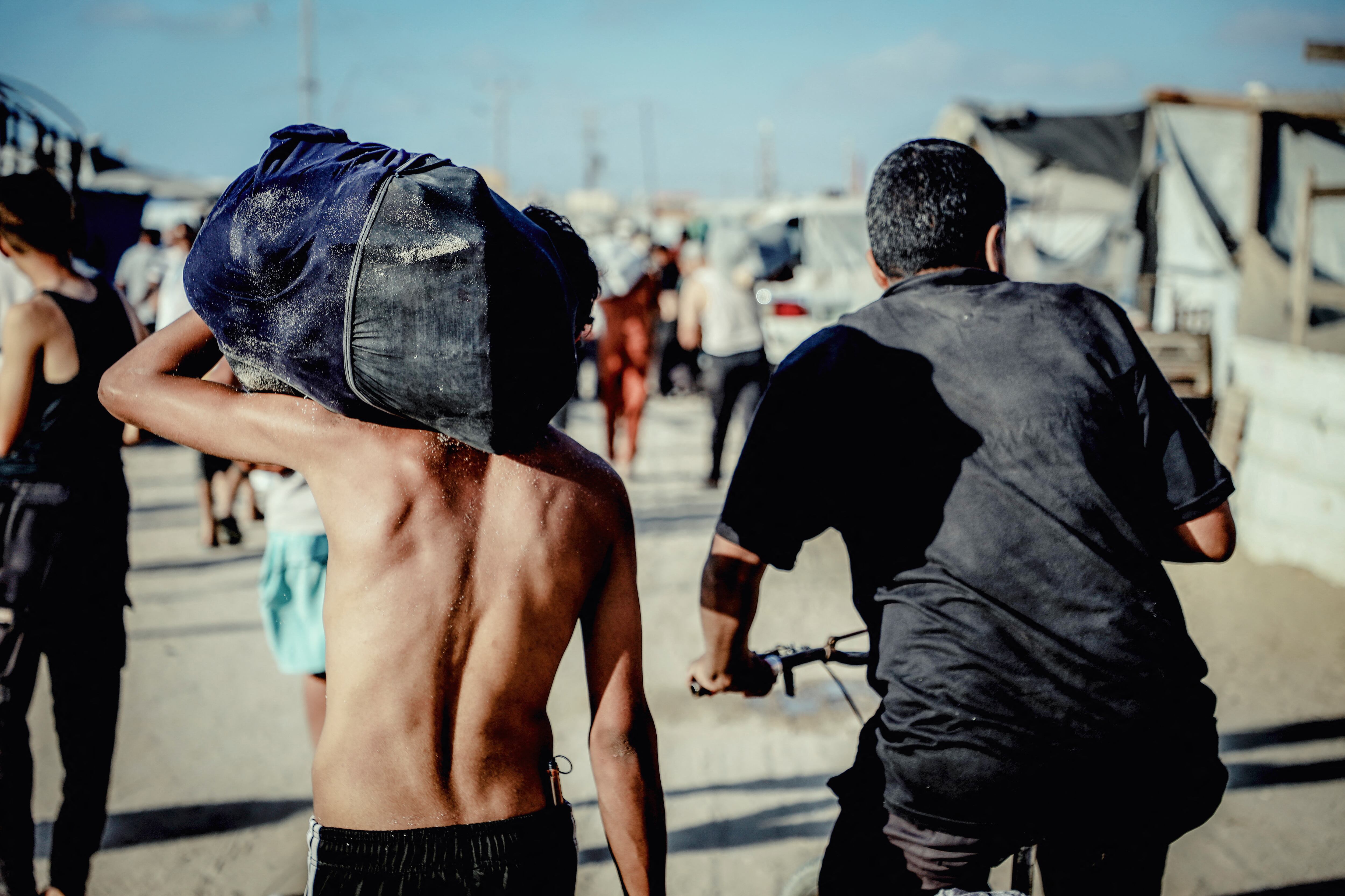 Ciudadanos palestinos cargan ayuda humanitaria de punto de distribución en la Franja de Gaza. FOTO: Saeed Jaras/Middle East Images/AFP /Getty Images