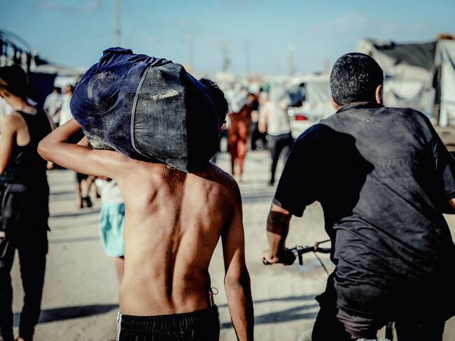 Ciudadanos palestinos cargan ayuda humanitaria de punto de distribución en la Franja de Gaza. FOTO: Saeed Jaras/Middle East Images/AFP /Getty Images