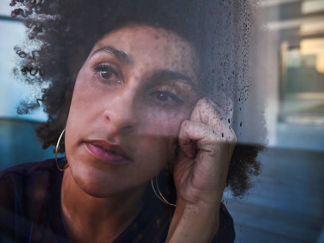 Woman looking through wet glass. Photo: Getty Images