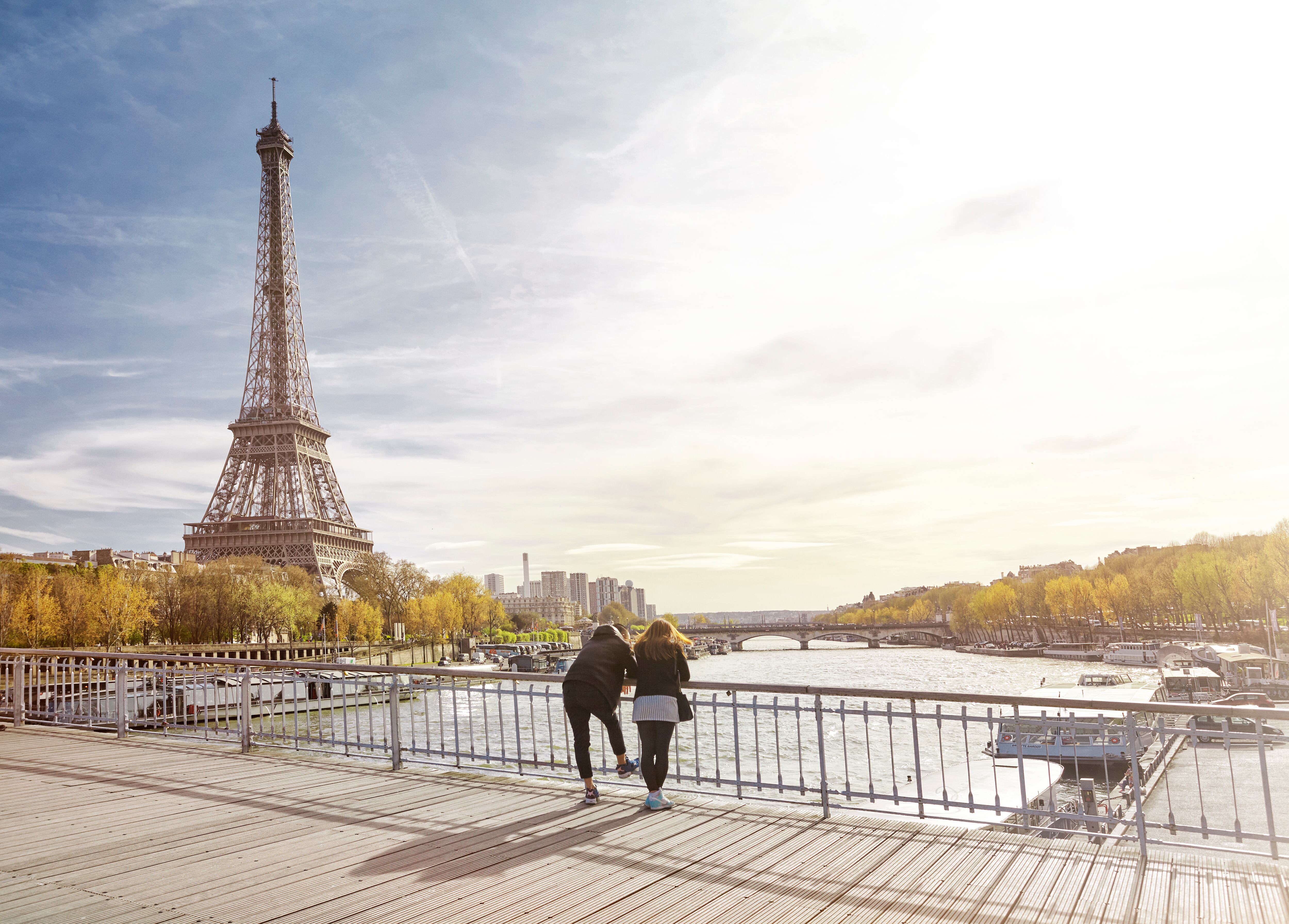 Pareja de turistas mirando la torre Eiffel en París, Francia (Foto vía GettyImages)