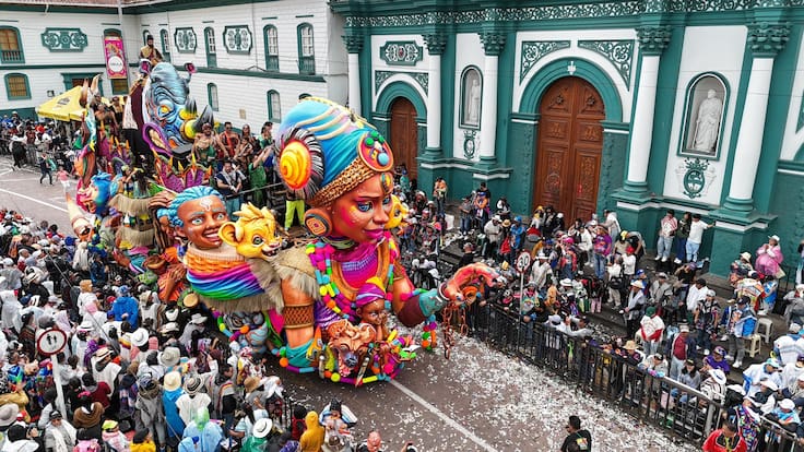 Óscar Ruano y el trasfondo de la carroza ganadora del Carnaval de Pasto