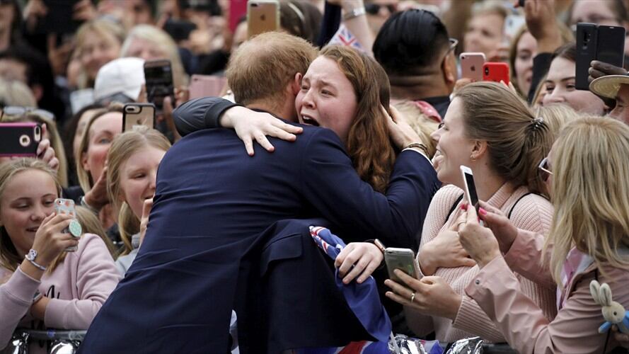 El príncipe Harry decidió abrazar a una joven que lo estaba esperando desde las 4:00 a.m.. Foto: Associated Press - AP