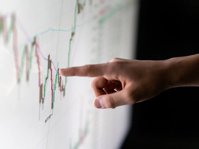 Finger pointing at market analysis with digital monitor