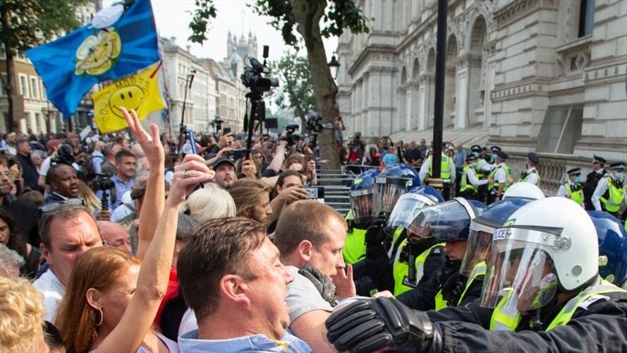 Los manifestantes contra el pasaporte de las vacunas se enfrentan a los agentes de policía fuera de las puertas del número 10 de Downing Street durante protestas. Foto: Getty Images/ SOPA Images