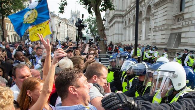 Los manifestantes contra el pasaporte de las vacunas se enfrentan a los agentes de policía fuera de las puertas del número 10 de Downing Street durante protestas. Foto: Getty Images/ SOPA Images