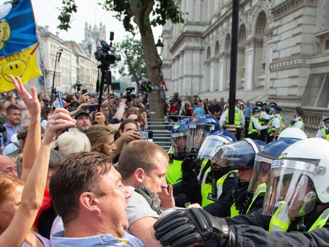 Los manifestantes contra el pasaporte de las vacunas se enfrentan a los agentes de policía fuera de las puertas del número 10 de Downing Street durante protestas. Foto: Getty Images/ SOPA Images