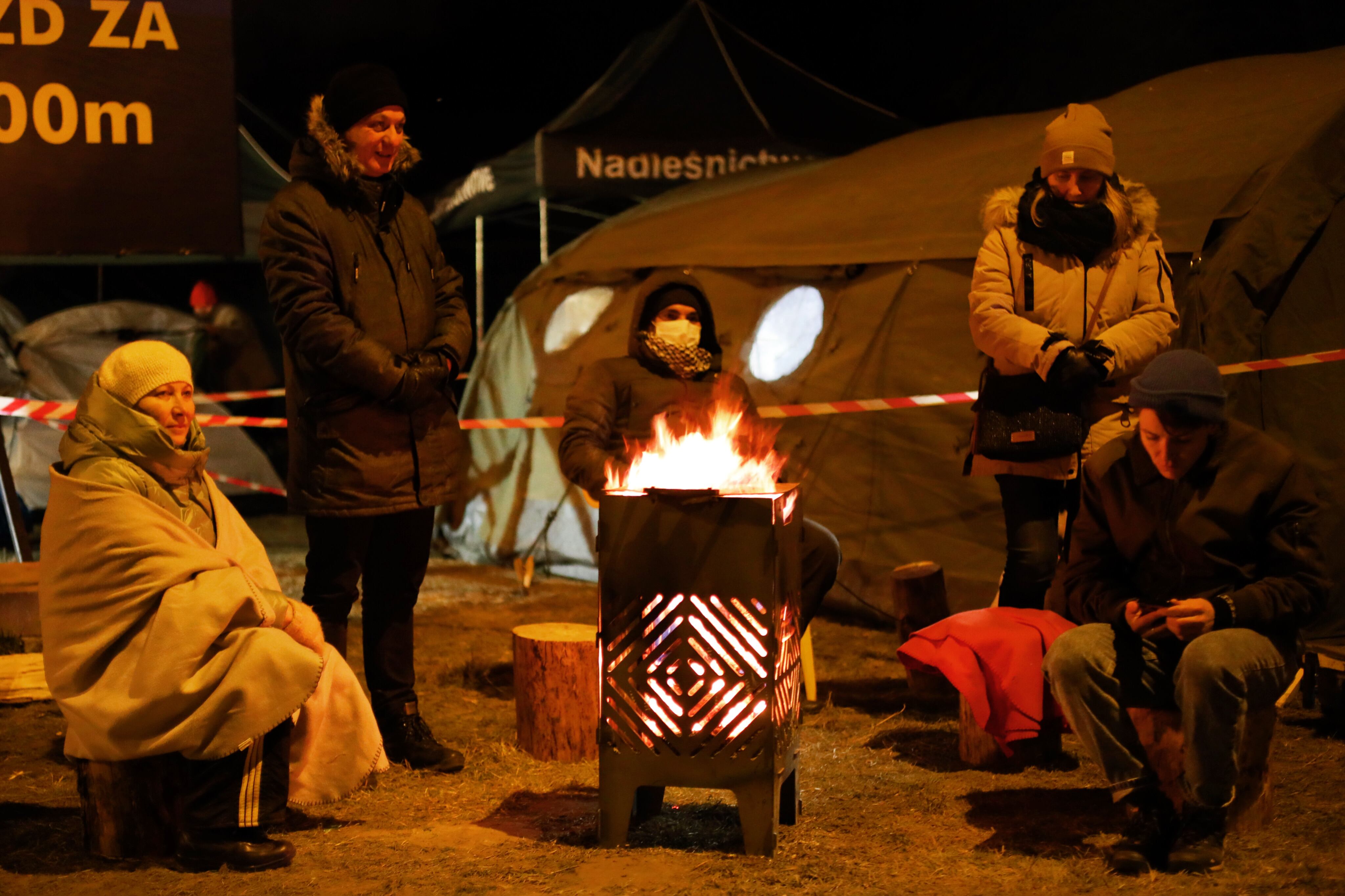 People arrived from war-torn Ukraine wait for relatives or Polish residents top pick them up at a border crossing to Ukraine Hrebenne, Poland, on March 3, 2022. (Photo by Ibrahim Ezzat/NurPhoto via Getty Images)