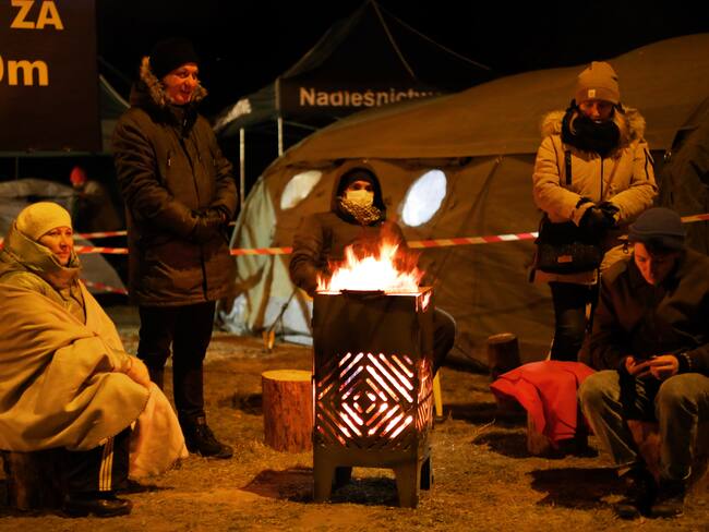 People arrived from war-torn Ukraine wait for relatives or Polish residents top pick them up at a border crossing to Ukraine Hrebenne, Poland, on March 3, 2022. (Photo by Ibrahim Ezzat/NurPhoto via Getty Images)