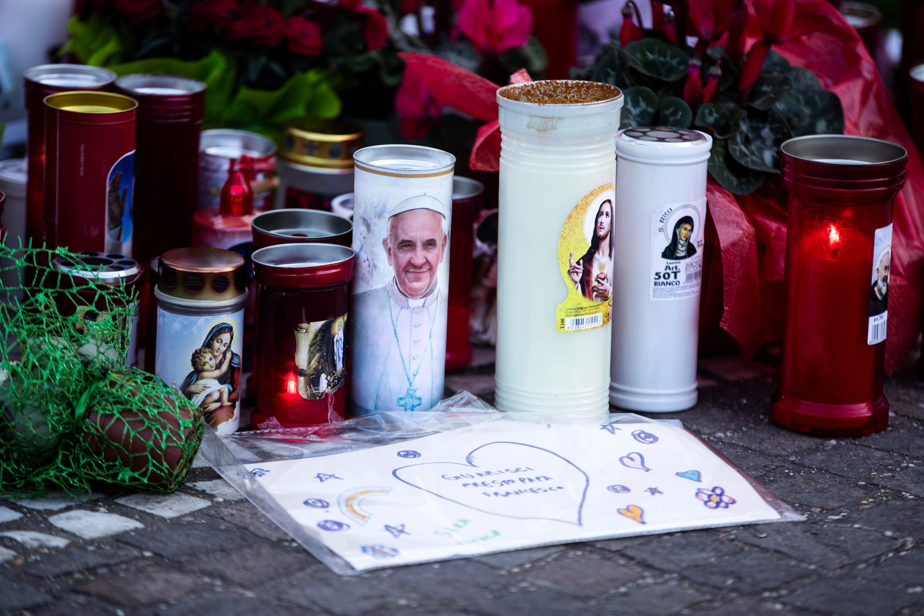ROMA (Italia), 05/03/2025.- Se colocan velas bajo la estatua de Juan Pablo II a la entrada del Hospital Gemelli, donde está hospitalizado el papa Francisco.