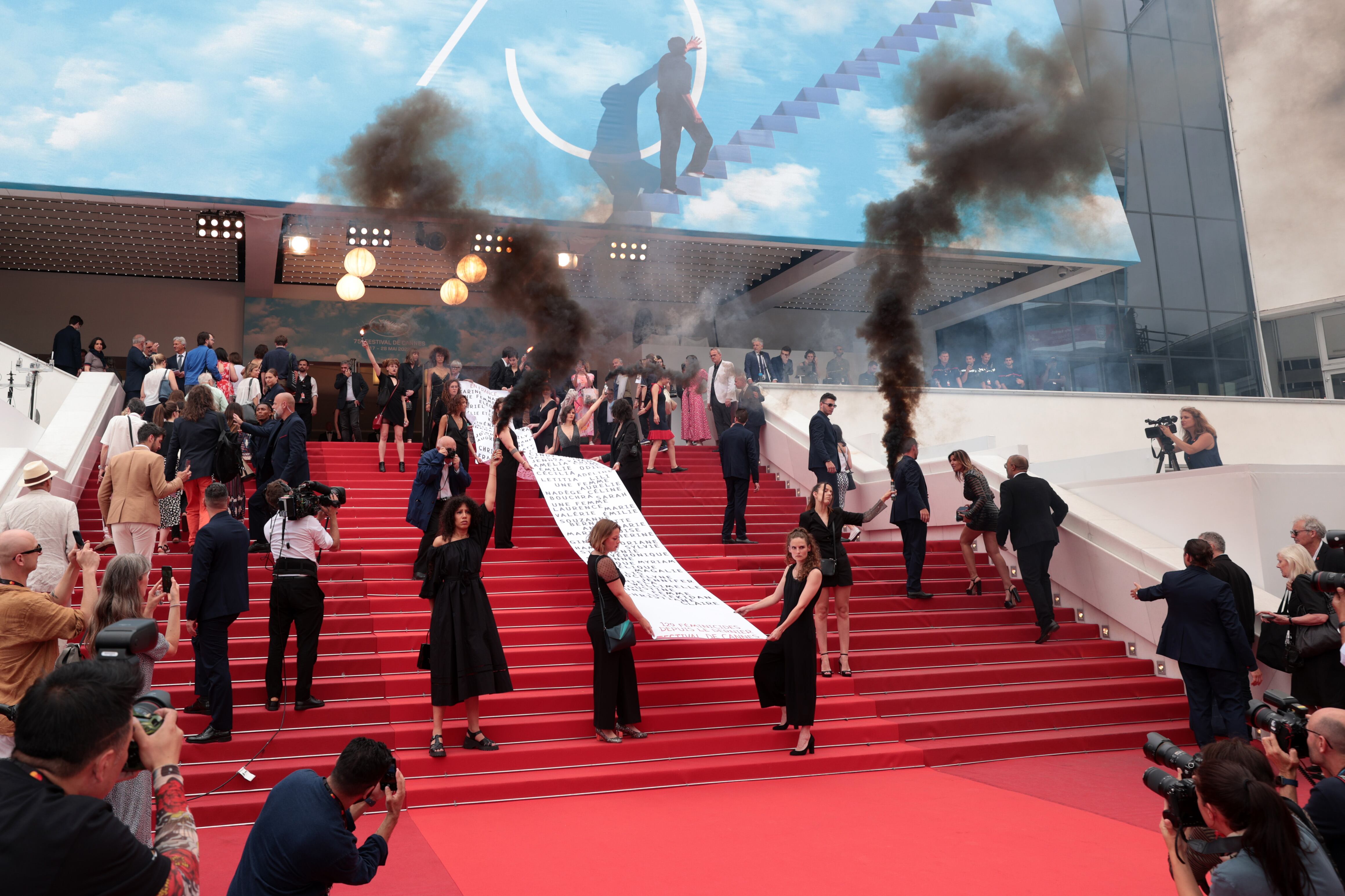 CANNES, FRANCE - MAY 22: Members of the feminist movement "Les Colleuses" hold a banner, displaying the names of 129 women who died as a result of domestic violence ahead of the screening of "Holy Spider" during the 75th annual Cannes film festival at Palais des Festivals on May 22, 2022 in Cannes, France. (Photo by John Phillips/Getty Images)