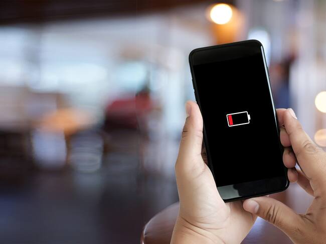 Hombre revisando su celular que se apagó por baja batería (Getty Images)