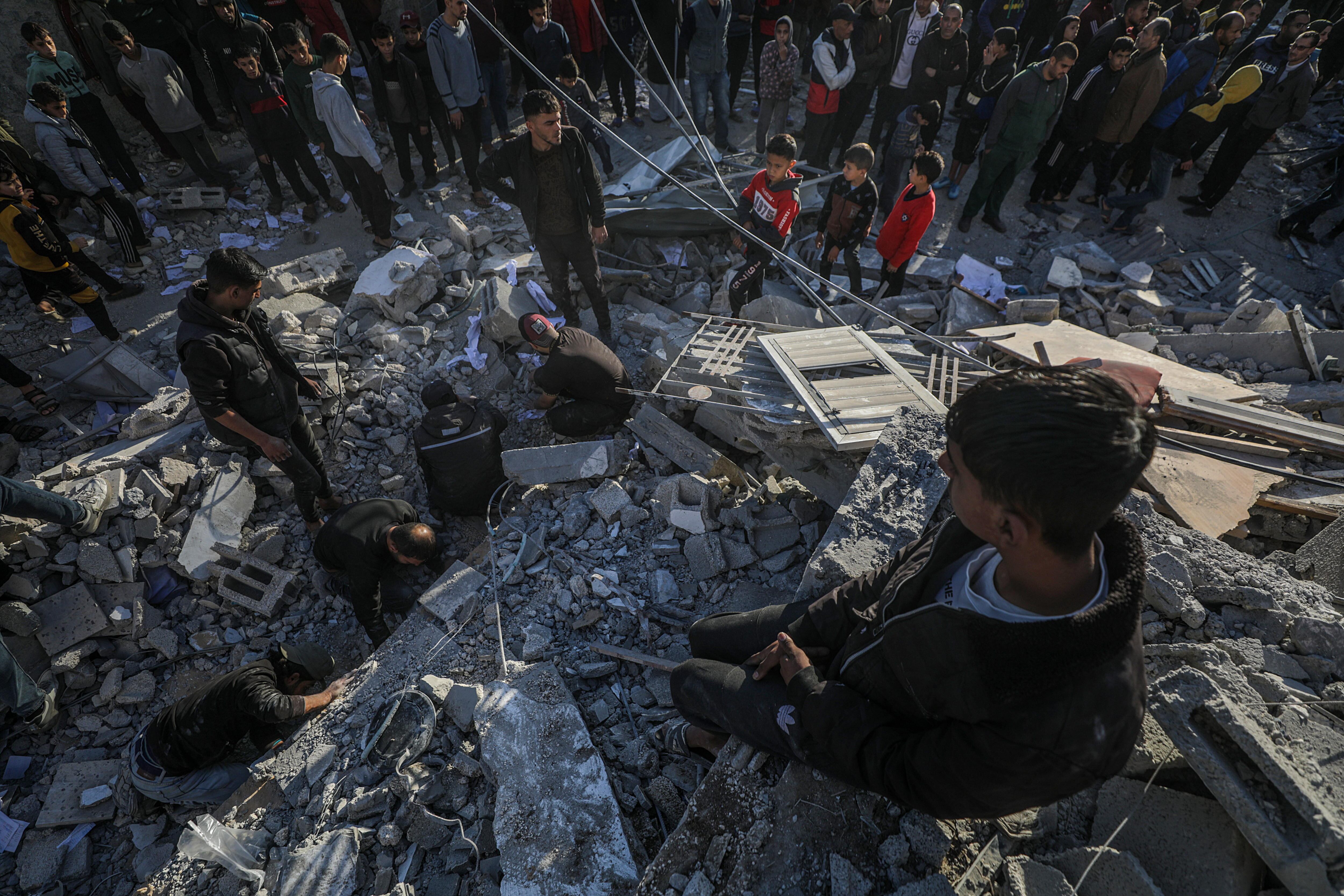 Al Nuseirat Camp (-), 13/12/2024.- Palestinians search for bodies and survivors among the rubble of destroyed buildings following Israeli airstrikes in Al Nuseirat refugee camp, central Gaza Strip, 13 December 2024. According to the Palestinian Ministry of Health in Gaza, at least 40 Palestinians were killed in an overnight Israeli airstrike in Al Nusairat refugee camp, central Gaza. More than 45,500 Palestinians and over 1,400 Israelis have been killed, according to the Palestinian Health Ministry and the Israeli Army, since Hamas militants launched an attack against Israel from the Gaza Strip on 07 October 2023 and the Israeli operations in Gaza and the West Bank that followed it. EFE/EPA/MOHAMMED SABER