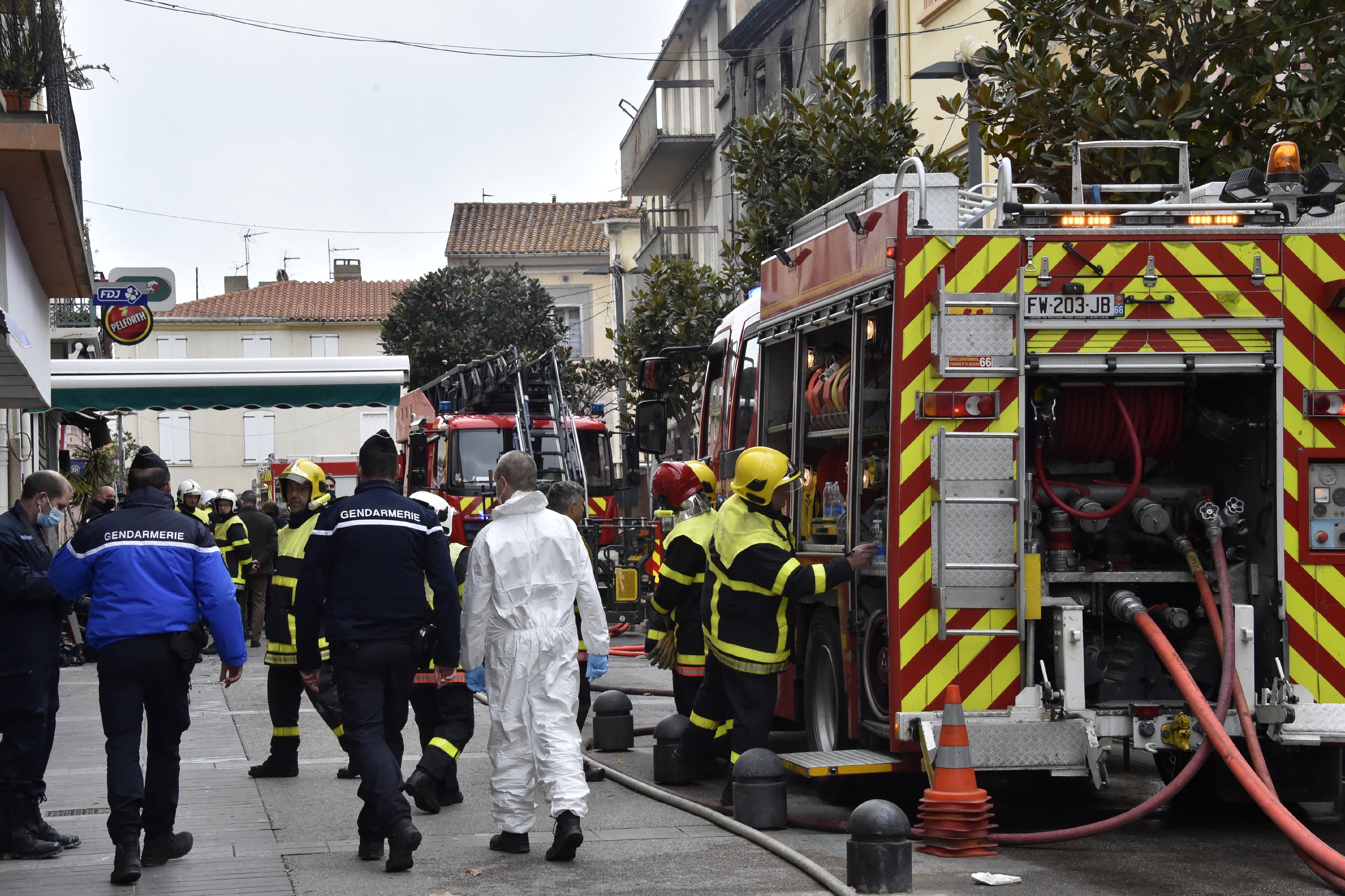 Gendarmes and firefighters are at work at the site of a fire that broke out in a habitation building, killing seven of its residents in Saint-Laurent-de-la- Salanque, on February 14, 2022. (Photo by RAYMOND ROIG / AFP) (Photo by RAYMOND ROIG/AFP via Getty Images)