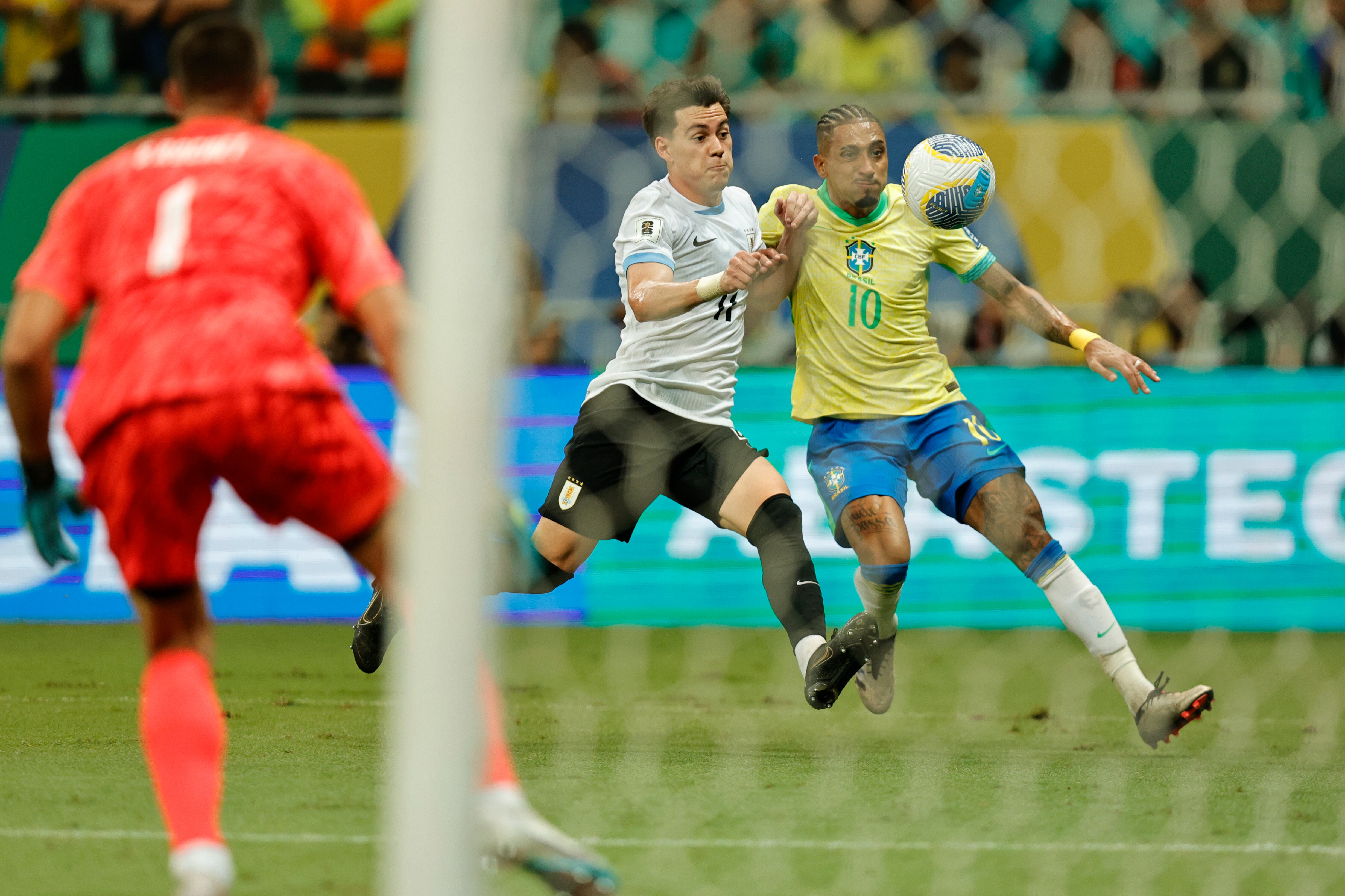 Raphinha de Brasil disputa el balón con Facundo Pellistri de Uruguay este martes, en un partido de las eliminatorias sudamericanas para el Mundial de 2026 entre Brasil y Uruguay, en el estadio Arena Fonte Nova en Salvador (Brasil). EFE/ Isaac Fontana