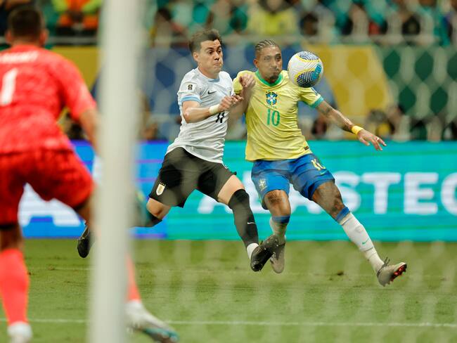 Raphinha de Brasil disputa el balón con Facundo Pellistri de Uruguay este martes, en un partido de las eliminatorias sudamericanas para el Mundial de 2026 entre Brasil y Uruguay, en el estadio Arena Fonte Nova en Salvador (Brasil). EFE/ Isaac Fontana