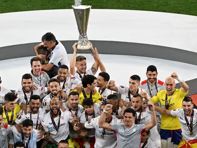 Sevilla&#039;s players celebrate with the trophy on the podium after winning the UEFA Europa League final football match between Sevilla FC and AS Roma at the Puskas Arena in Budapest on May 31, 2023. (Photo by Ferenc ISZA / AFP) (Photo by FERENC ISZA/AFP via Getty Images)