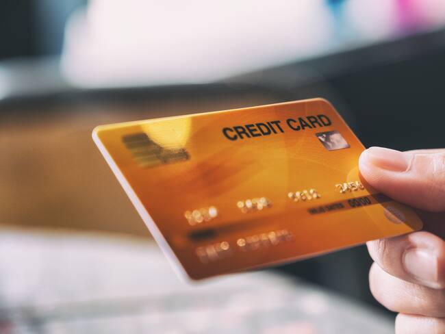 Persona sosteneindo una tarjeta de crédito en su mano (Foto vía Getty Images)