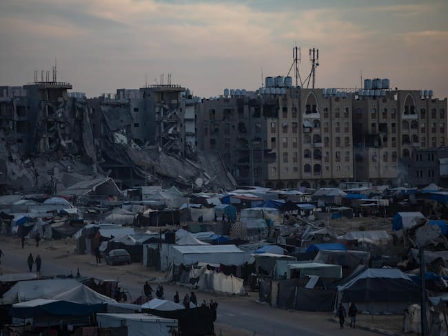 Khan Yunis (-), 22/12/2024.- Palestinos desplazados, que huyeron de sus hogares debido a los ataques aéreos israelíes y a las órdenes de evacuación, caminan entre tiendas de campaña en un campamento improvisado al atardecer en el campo de Khan Younis, sur de la Franja de Gaza, EFE/EPA/HAITHAM IMAD
