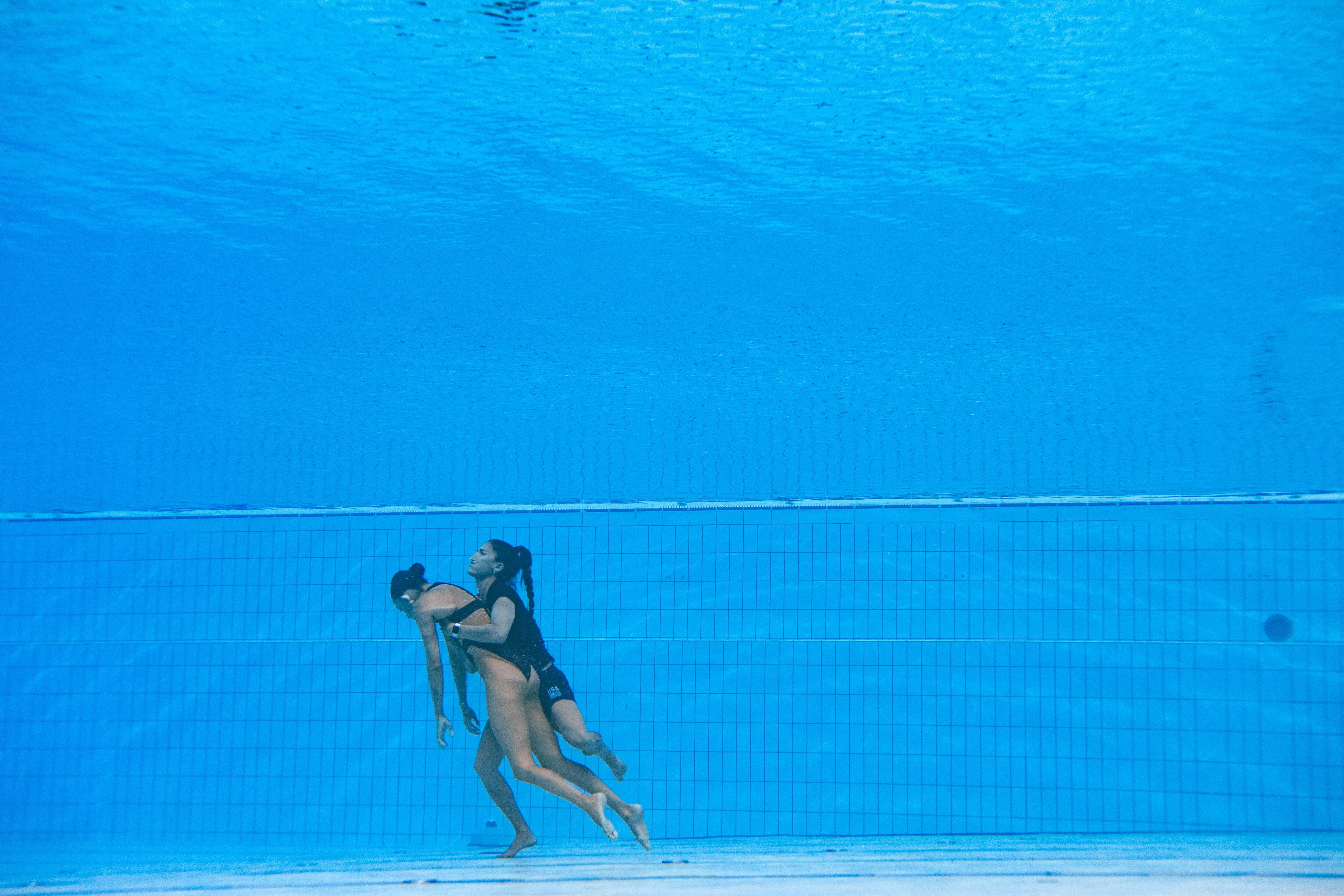 A member of Team USA (R) recovers USA's Anita Alvarez (L), from the bottom of the pool during an incident in the women's solo free artistic swimming finals, during the Budapest 2022 World Aquatics Championships at the Alfred Hajos Swimming Complex in Budapest on June 22, 2022. (Photo by Oli SCARFF / AFP)