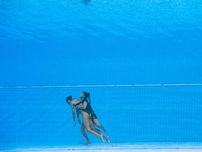 A member of Team USA (R) recovers USA&#039;s Anita Alvarez (L), from the bottom of the pool during an incident in the women&#039;s solo free artistic swimming finals, during the Budapest 2022 World Aquatics Championships at the Alfred Hajos Swimming Complex in Budapest on June 22, 2022. (Photo by Oli SCARFF / AFP)