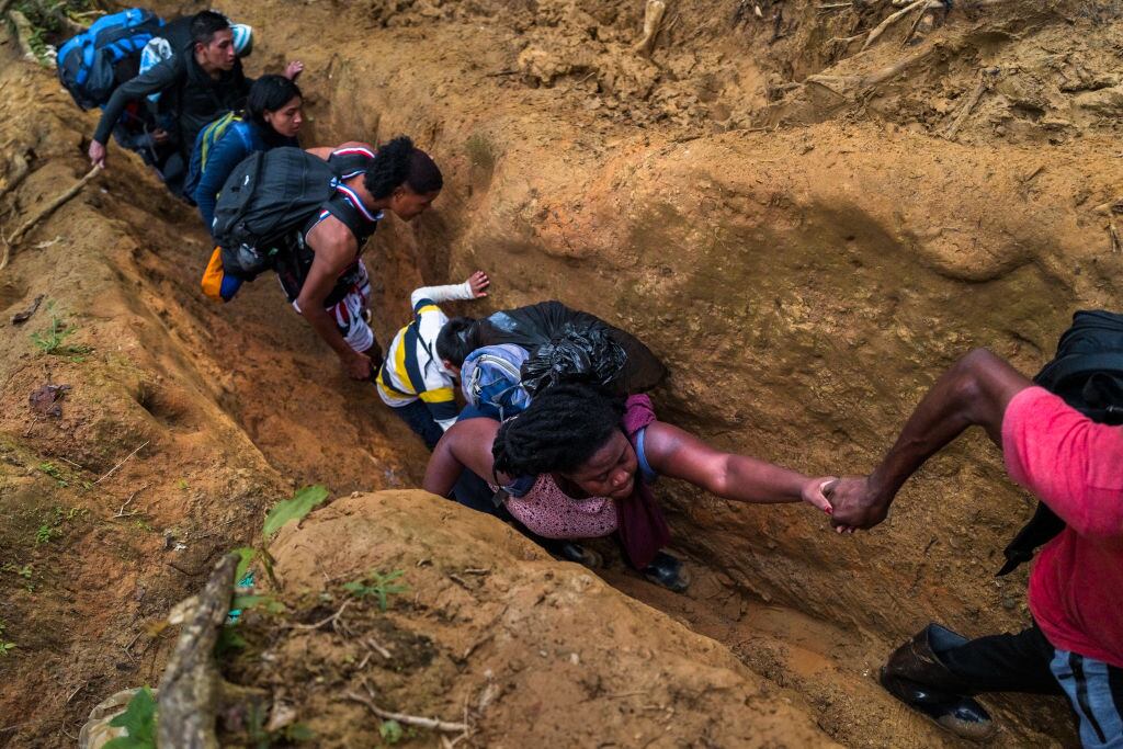 Migrantes intentando cruzar la selva del Darién, por un tramo muy angosto. Foto: Getty Images.