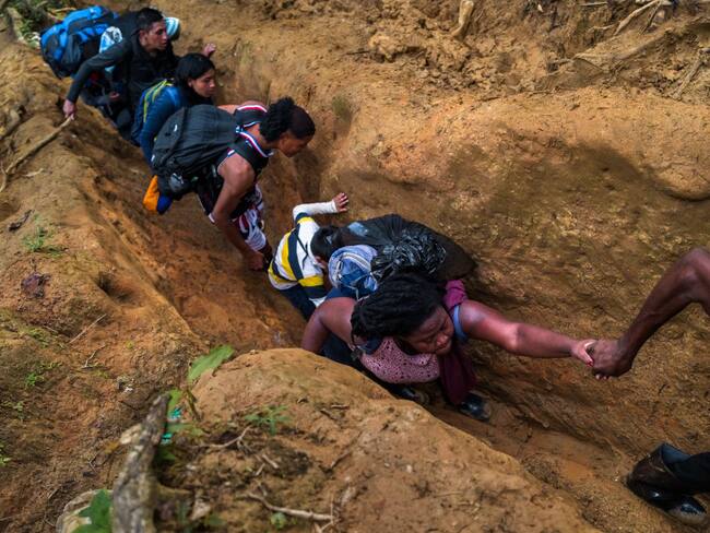 Migrantes intentando cruzar la selva del Darién, por un tramo muy angosto. Foto: Getty Images.
