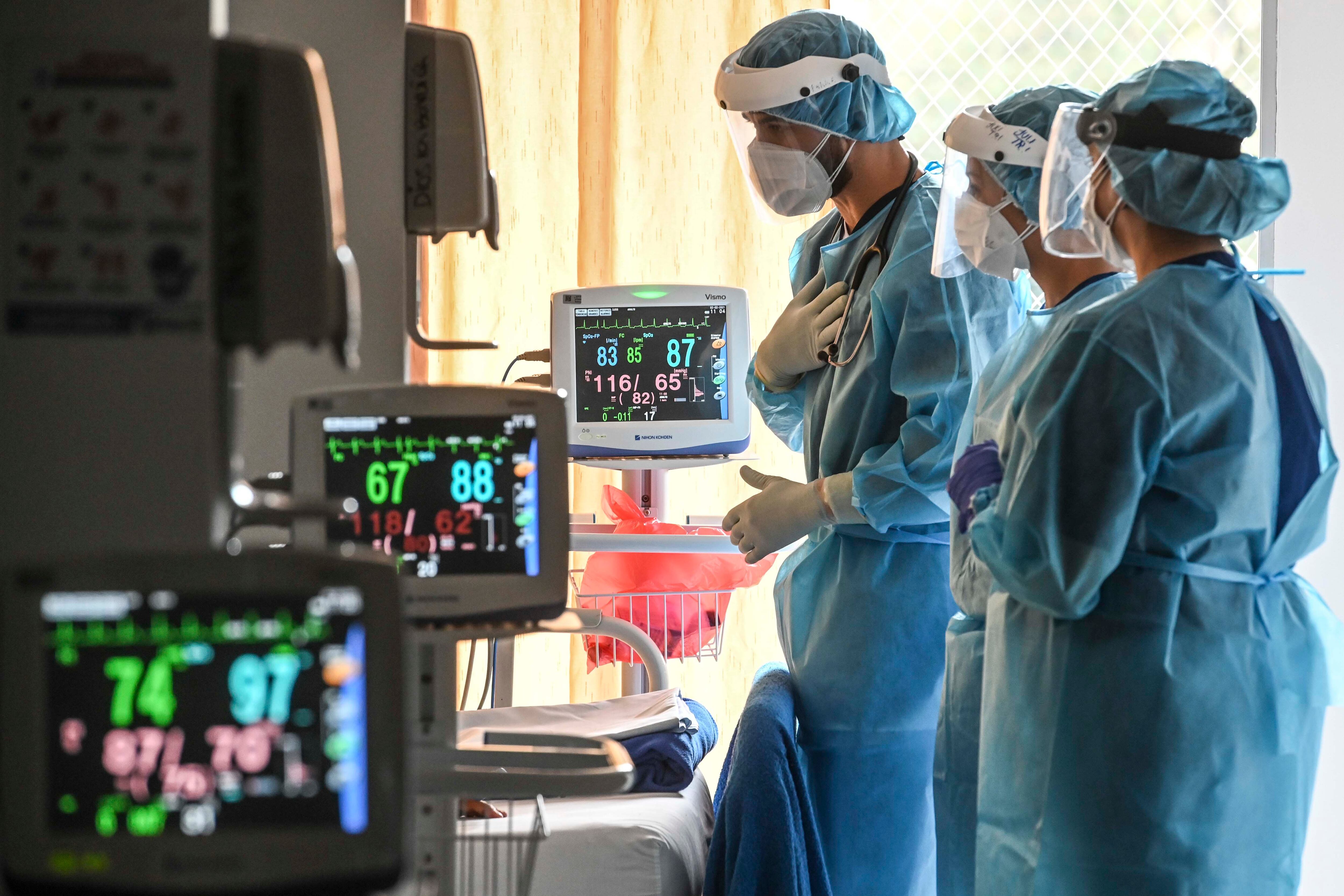 Trabajadores de la salud revisan a un paciente con COVID-19 en la unidad de cuidados respiratorios no invasivos de una clínica de la EPS SURA en Medellín, Colombia, el 2 de febrero de 2021. AFP vía Getty Images