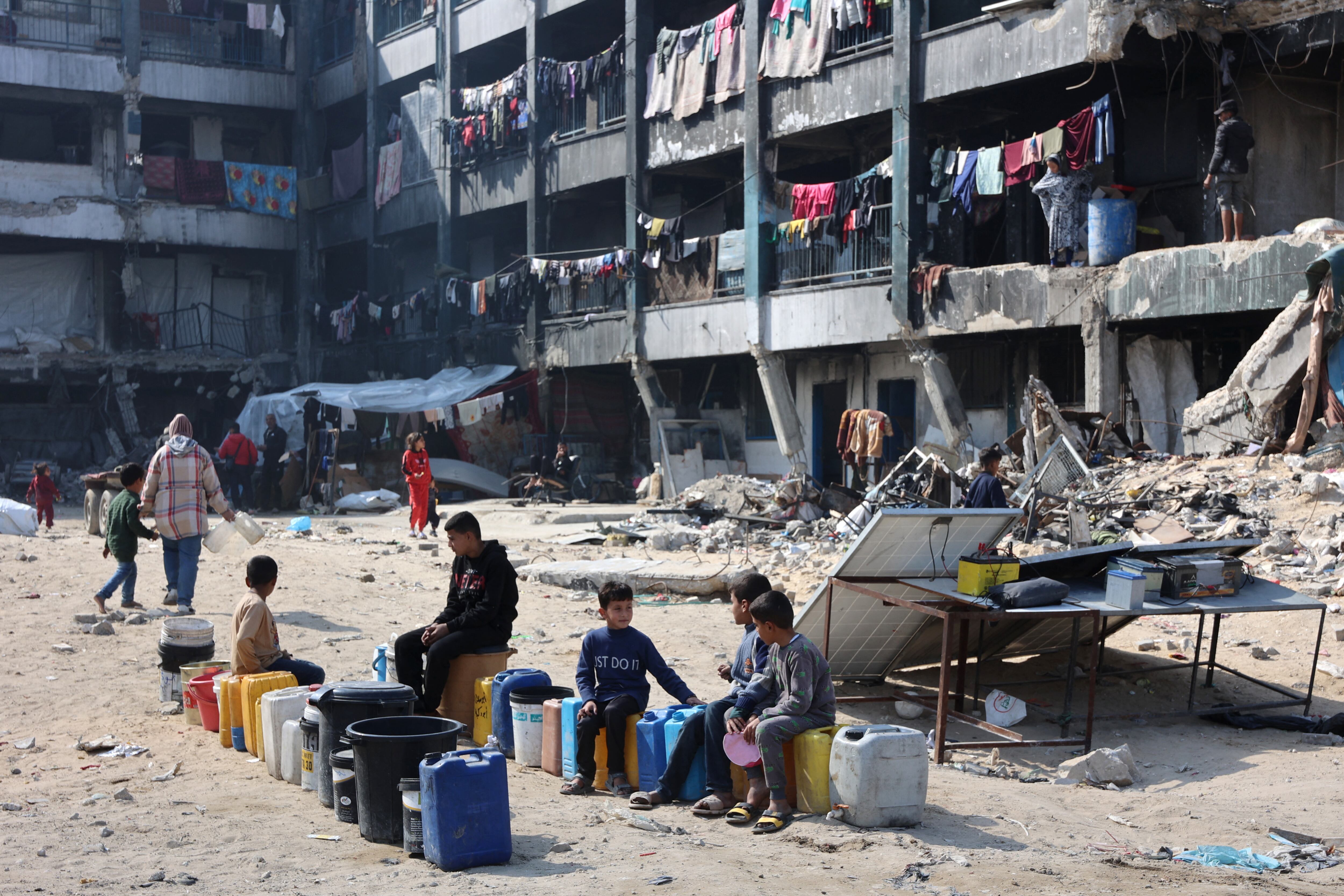 Niños al norte de Gaza, sentados en bidones de agua. FOTO; Omar AL-QATTAA via Getty Images