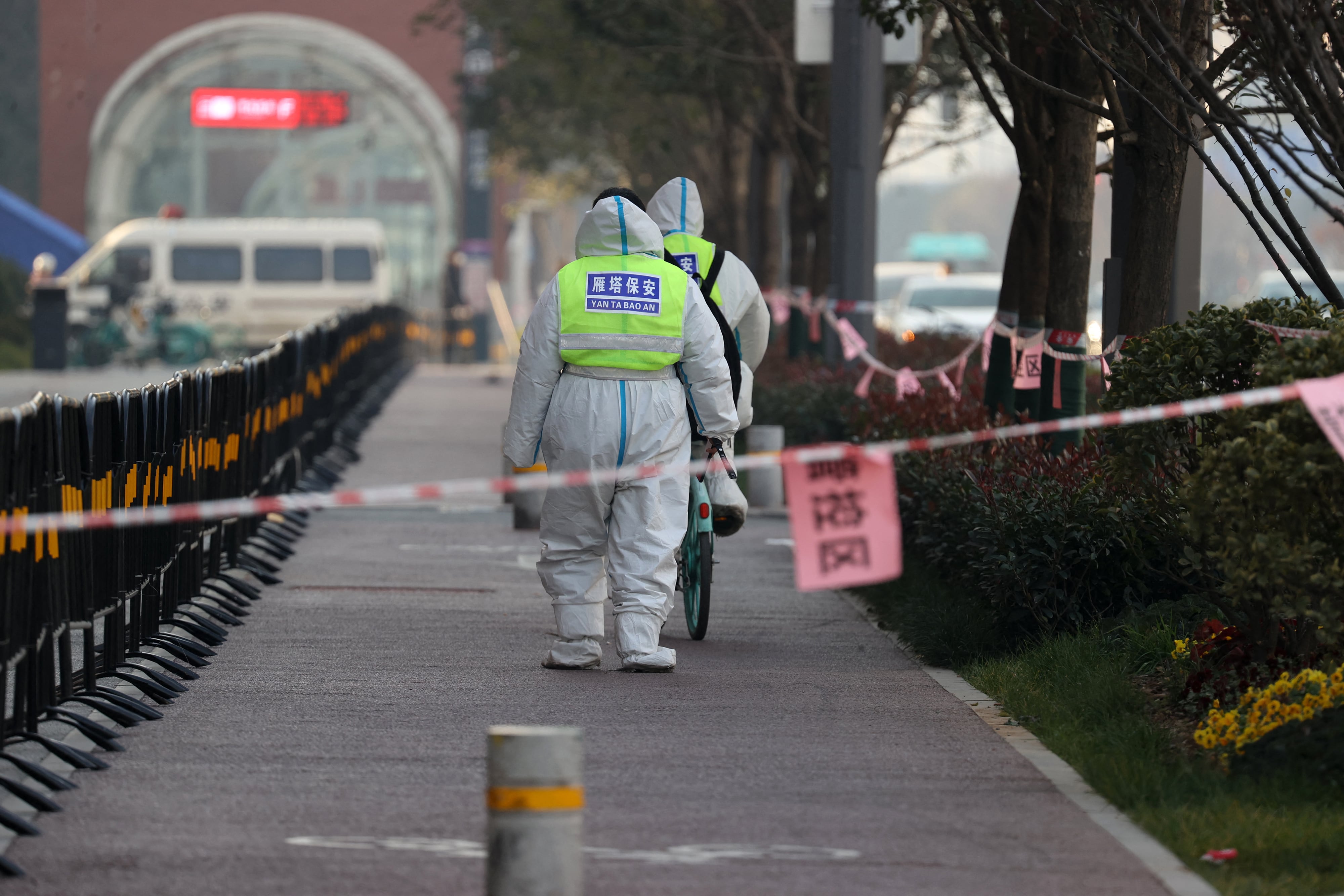 This photo taken on December 22, 2021 shows security guards walking in an area that is under restrictions following a recent coronavirus outbreak in Xi'an in China's northern Shaanxi province. - China OUT (Photo by AFP) / China OUT (Photo by STR/AFP via Getty Images)